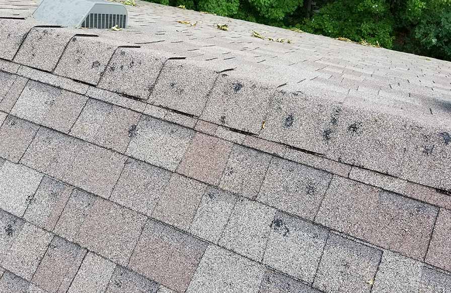 Brown roof with several roof hail damage that is needing roof hail damage repair in Minneapolis, MN