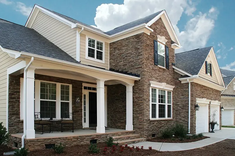 house with a combination of light beige siding and brown stone facade with several ProVia windows in Minneapolis, MN