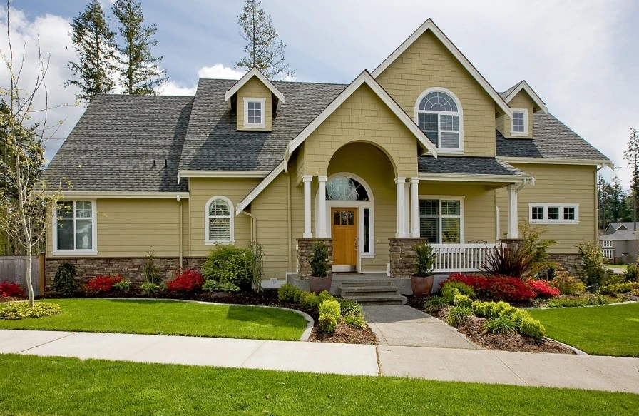 House with light yellow siding and a gray shingle roof with Provia Windows in Minneapolis, MN