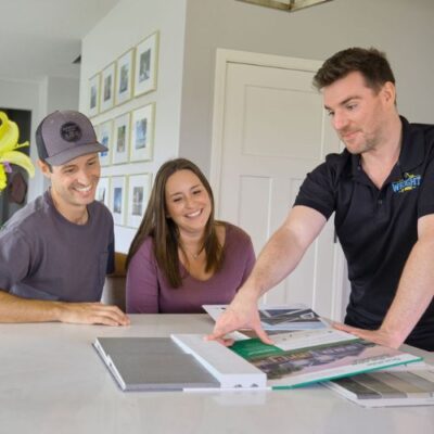 Wright at Home Roofing & Exteriors crew member inside a home speaking with a male and a female customer for roof replacement in Minneapolis, MN