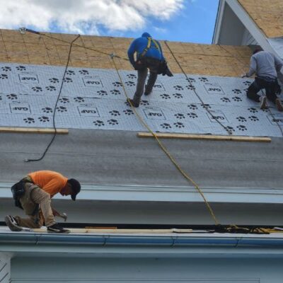 workers on top of a roof completing an installation Wright at Home Roofing & Exteriors in Minneapolis, MN