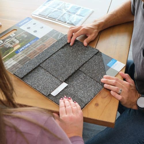 Homeowner discussing roof replacement costs and coverage options with an insurance agent