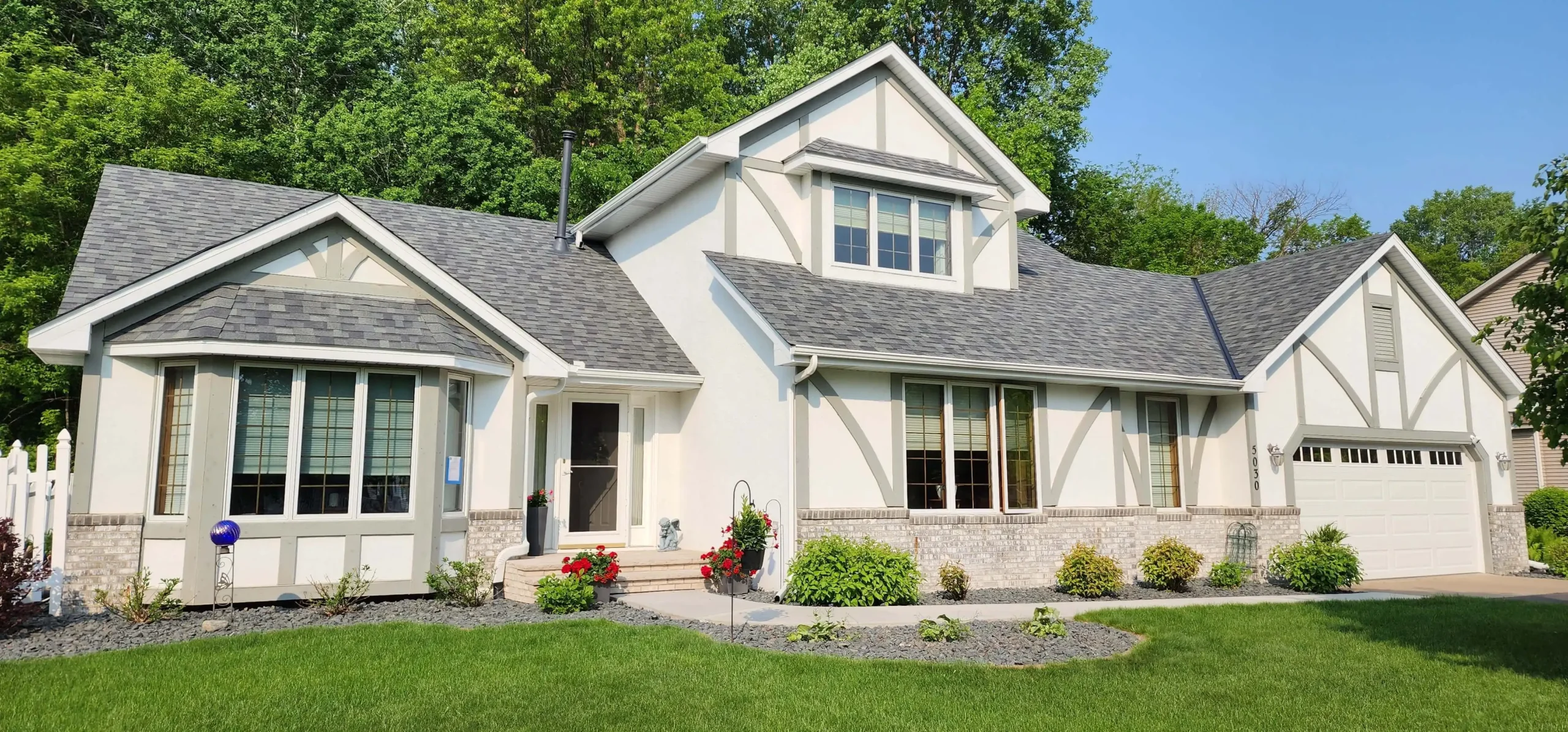 Exterior view of a fully renovated home featuring new roofing, siding, and trim by Wright at Home Roofing & Exteriors in Maple Grove