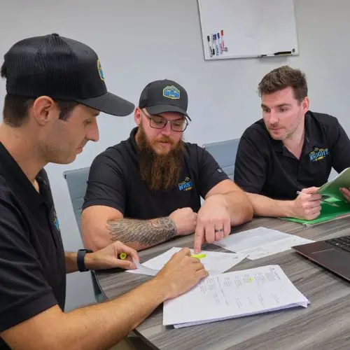 Roofing professionals collaborating during a team training session by Wright at Home Roofing & Exteriors in Minneapolis