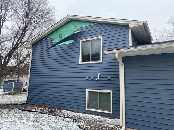 Visible exterior damage to a home's roof and siding