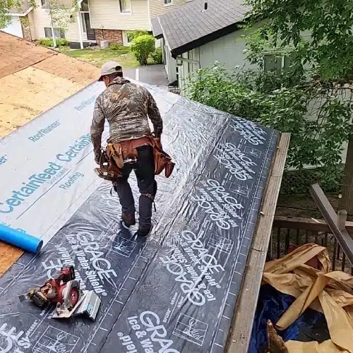 Contractor applies Grace ice and water shield membrane to the eaves of a Minneapolis roof for maximum leak protection by Wright at Home Roofing & Exteriors