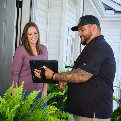 Homeowner discussing roof insurance claim tips and reviewing documentation with a roofing professional at her Minneapolis home by Wright at Home Roofing & Exteriors in Minneapolis