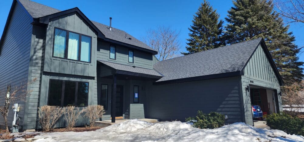 Two-story modern house with dark gray siding, black trim and a gray roof installed by a residential roofing contractor in Minneapolis, MN