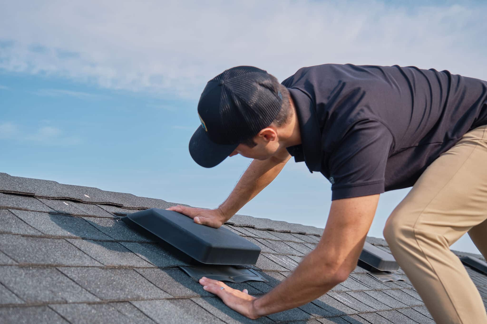 Addison Kaasa on top of a black roof in a process of roof inspection in Minneapolis, MN