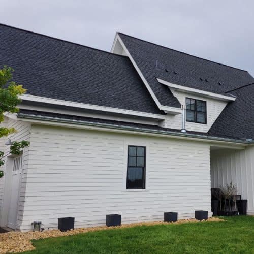 ariel image of a completed roof installation on a house with black shingles and white siding by Wright at Home Roofing & Exteriors in Minneapolis, MN
