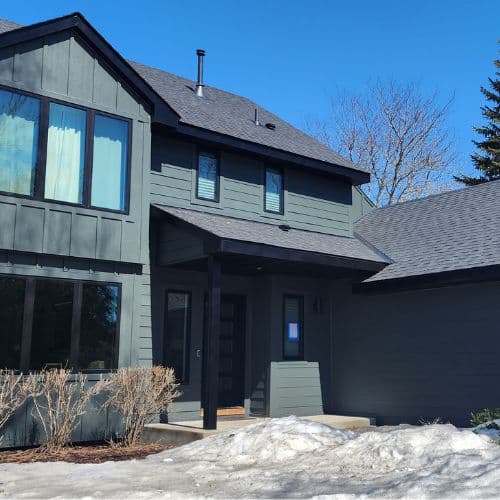two-story house with dark gray siding, black trim, and a gray roof in Minneapolis, MN