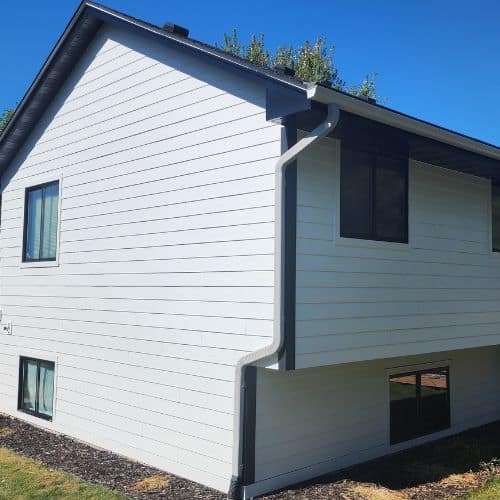 Light gray Hardie Plank lap siding on a two-story house with dark gray trim and black windows.