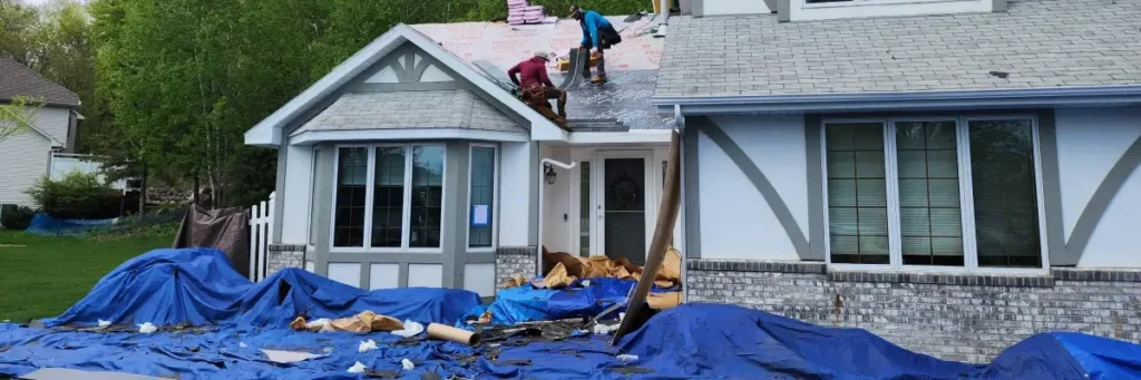 Residential home with two roofing contractors installing new shingles and underlayment, showcasing roofing contractor Minnesota by Wright at Home Roofing & Exteriors, Minneapolis, MN