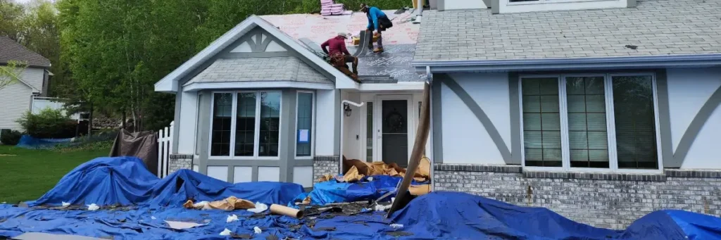 Residential home with two roofing contractors installing new shingles and underlayment, showcasing roofing contractor Minnesota by Wright at Home Roofing & Exteriors, Minneapolis, MN