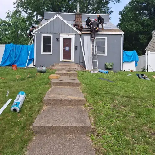 Roofing contractors installing before a new roof on a gray home in St. Louis Park, MN, as part of residential roofing and siding services.