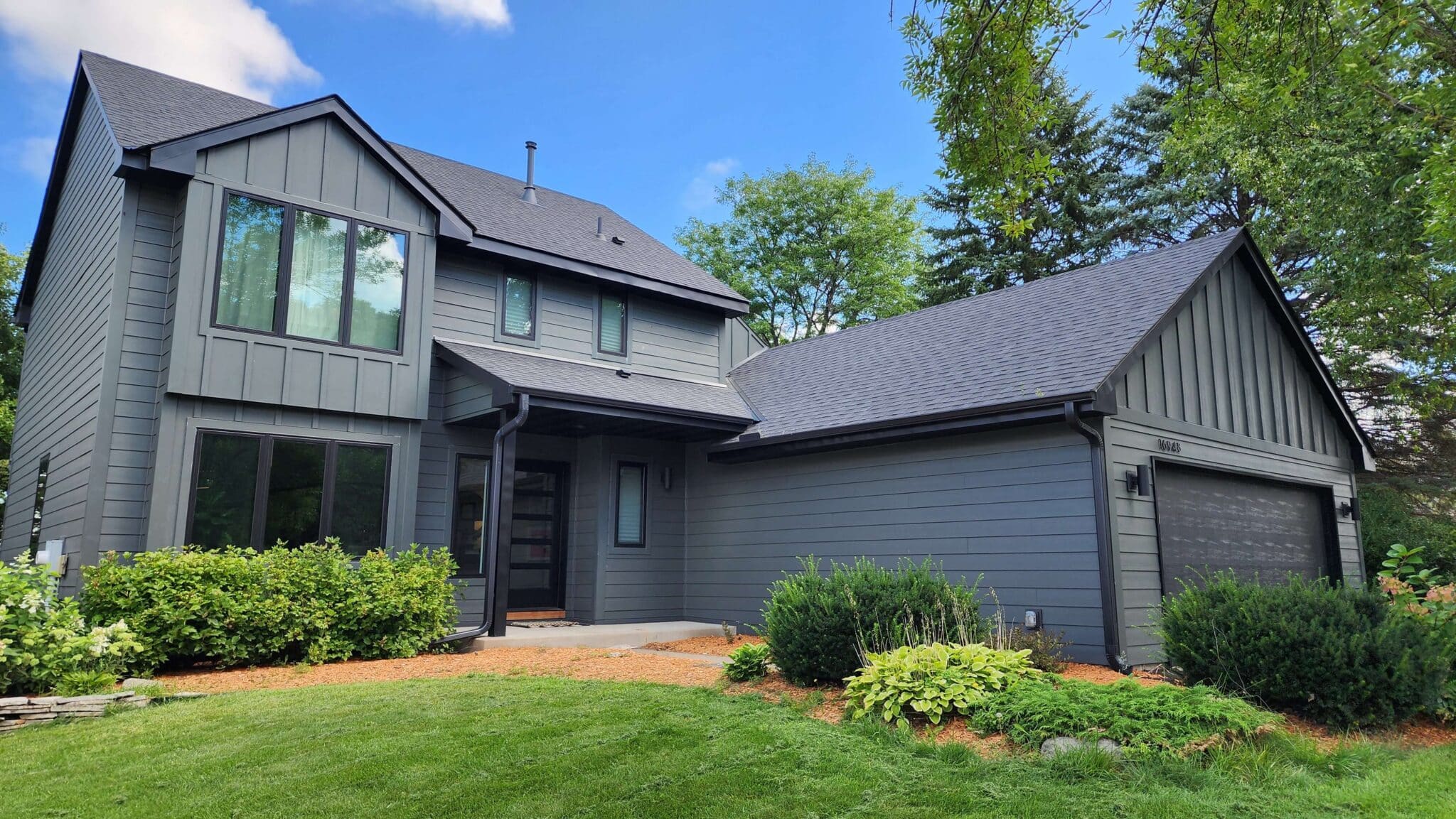 Modern Two-Story Gray House with Black Accents and Attached Garage