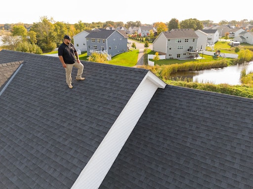 Roofing contractor inspecting residential roof by Wright at Home Roofing & Exteriors in Brooklyn Center
