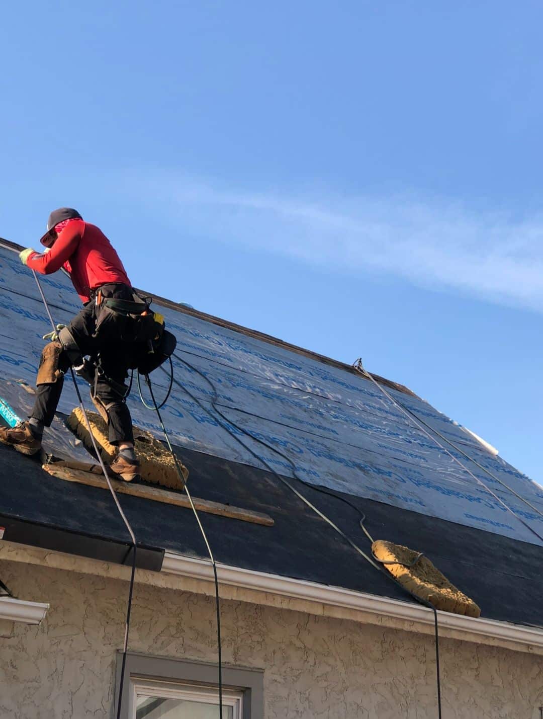 Skilled roofing contractor installing new roof underlayment by Wright at Home Roofing & Exteriors in Brooklyn Center