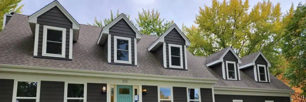 Dark gray siding and roof renovation with dormer windows by Wright at Home Roofing & Exteriors
