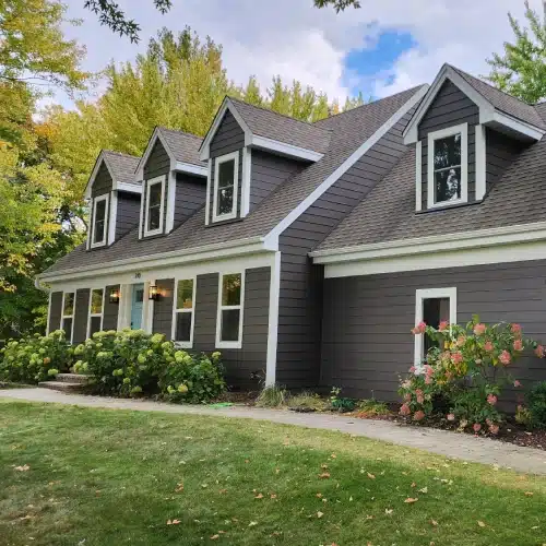 Dark siding and roofing transformation on remodeled suburban home by Wright at Home Roofing & Exteriors
