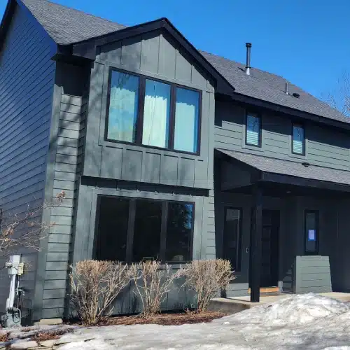 Two-story home remodel featuring dark gray siding and updated exterior details by Wright at Home Roofing & Exteriors