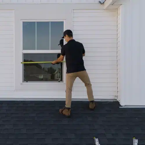 Technician measuring window for replacement windows installation by Wright at Home Roofing & Exteriors in Minneapolis