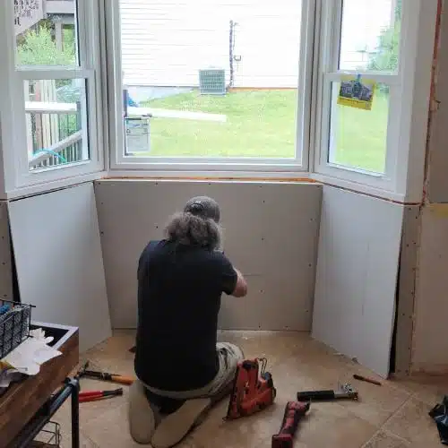 Contractor installing new interior bay window replacement by Wright at Home Roofing & Exteriors in Blaine MN