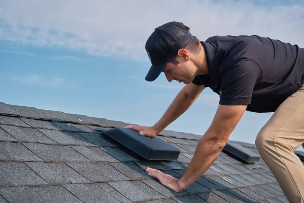 Addison Kaasa, owner of Wright at Home Roofing & Exteriors, completing a roof inspection on top of a black shingle roof in Minneapolis, MN
