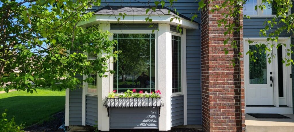 Bay window with white trim and flower planter exterior remodeling Oakdale MN service in Minneapolis by Wright at Home Roofing & Exteriors