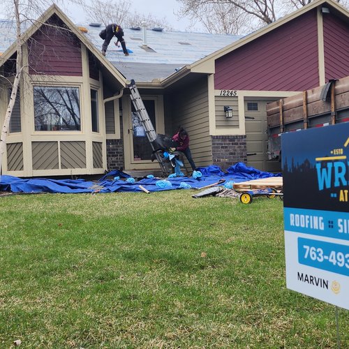 Wright at Home yard sign and roofing crew on site during a roof replacement in Minnesota