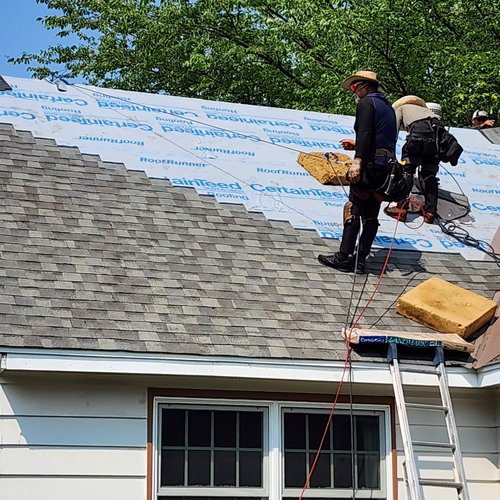 Wright at Home roofers tearing off old shingles during a roof replacement in Minnesota
